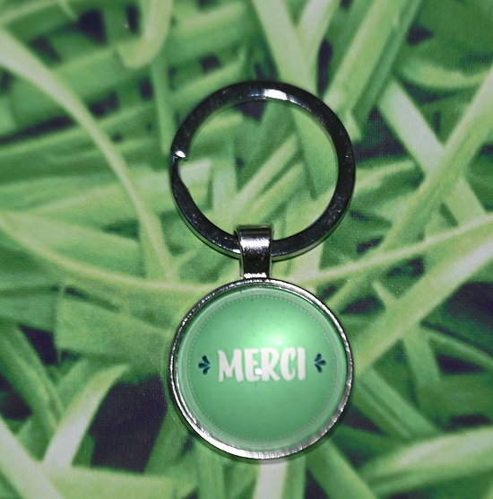 Porte-clef MERCI vert en métal argenté et verre